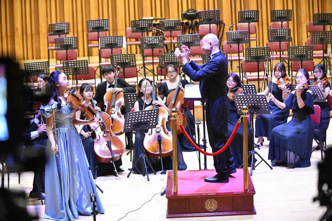 Ruby Ngọc Minh performing with the orchestra and conductor